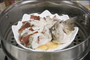 將鱸魚成花狀擺好，將火腿切片放入各縫隙中，放入鍋中隔水蒸12分鐘拿出，撒上蔥花即可。