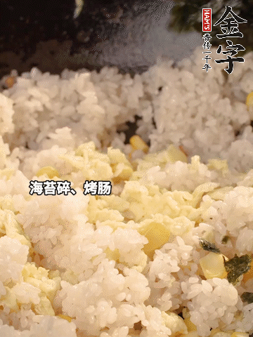 剩米飯下鍋炒散，依次下玉米粒、雞蛋、烤腸、海苔碎翻炒均勻。