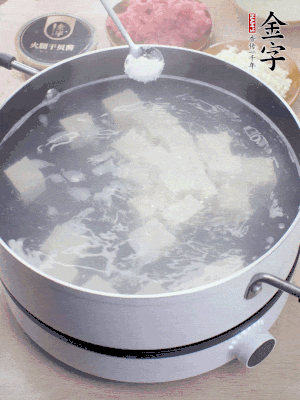 豆腐切成大小均勻正方體，鍋內(nèi)放水，加一點鹽焯水10秒。
